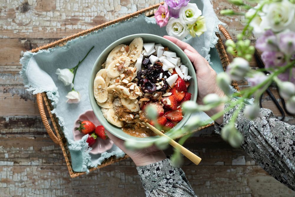 Bowl of nourishing muesli in nature representing healing the relationship with food through emotional eating therapy.